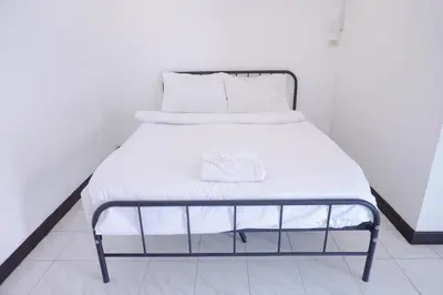 a bed with white sheets and white pillows at XX GO INN Patong Beach หาดป่าตอง in Patong Beach