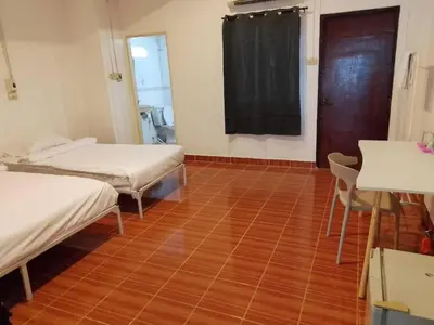 a room with two beds and a wooden floor at XX GO INN Patong Beach หาดป่าตอง in Patong Beach