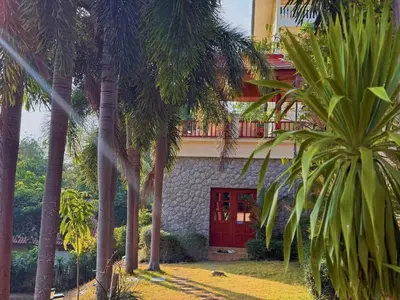 a building with a red door and palm trees at Kata Sea Cloud Villa\u534a\u5c71\u6d77\u666f\u72ec\u680b\u522b\u5885 in Kata Beach