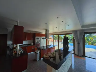 a kitchen with red cabinets and a view of a pool at Kata Sea Cloud Villa\u534a\u5c71\u6d77\u666f\u72ec\u680b\u522b\u5885 in Kata Beach