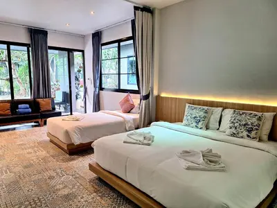 a hotel room with two beds and windows at Seava House Ao-Nang Krabi in Ao Nang Beach