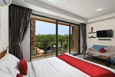 a bedroom with a bed and a large window at Studio 777 condo MaiKhao in Phuket Town