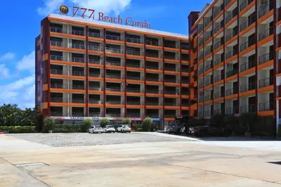 a large building with cars parked in a parking lot at Studio 777 condo MaiKhao in Phuket Town