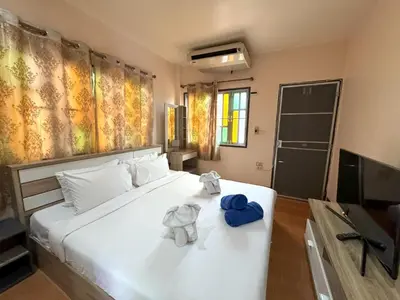 a bedroom with a bed with two stuffed elephants on it at Kamala beach house 100m to the beach in Kamala Beach