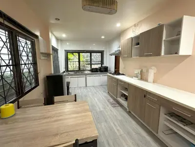 a large kitchen with a wooden table in a room at Kamala beach house 100m to the beach in Kamala Beach