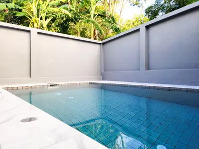 a swimming pool with blue tiles on a fence at Calm & Cozy Vacation House in Rawai Beach