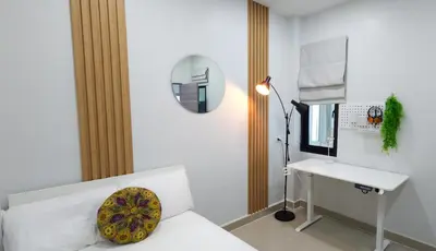 a bedroom with a bed with a desk and a mirror at Calm & Cozy Vacation House in Rawai Beach