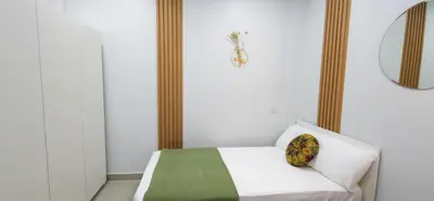 a bedroom with a white bed with a pillow on it at Calm & Cozy Vacation House in Rawai Beach