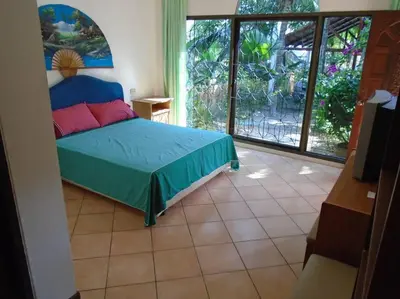 a bedroom with a bed and a large window at Baan Coconut in Bang Tao Beach