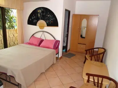 a bedroom with a bed with pink pillows on it at Baan Coconut in Bang Tao Beach