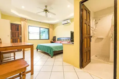 a bedroom with a bed and a bathroom with a shower at Baan Coconut in Bang Tao Beach