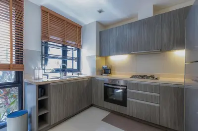 a kitchen with wooden cabinets and a sink at Laguna Parkside by Triple8 Asia in Laguna Phuket