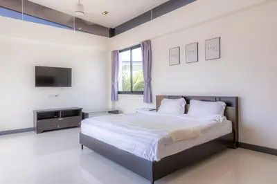 a bedroom with a large bed and a tv at Laguna Parkside by Triple8 Asia in Laguna Phuket