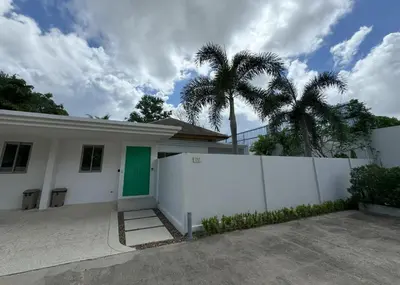 a white house with a green door and palm trees at Trichada Tropical pool villa by Lofty in Bang Tao Beach