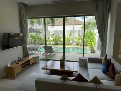 a living room with a couch and a table at Trichada Tropical pool villa by Lofty in Bang Tao Beach