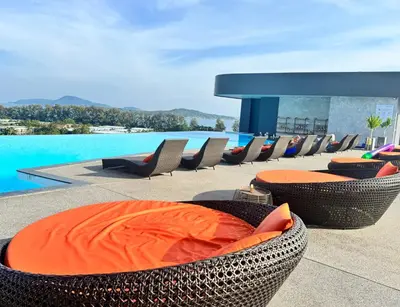 a patio with chairs and a swimming pool with a pool at Luxury studio near Nai Harn beach in Rawai Beach