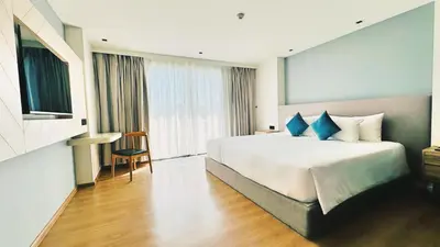 a hotel room with a large bed with blue pillows at Luxury studio near Nai Harn beach in Rawai Beach