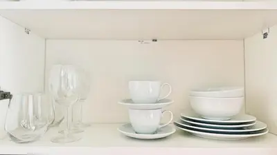 a white shelf with plates and bowls and glasses at Luxury studio near Nai Harn beach in Rawai Beach