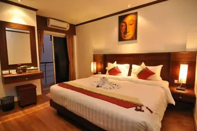 a bedroom with a large bed and a mirror at Hemingway's Hotel in Patong Beach