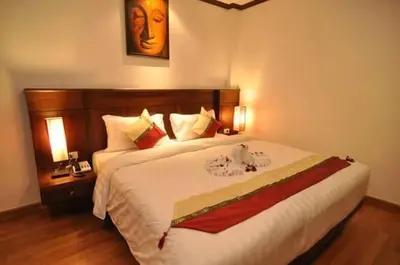 a bedroom with a large white bed with two lamps at Hemingway's Hotel in Patong Beach