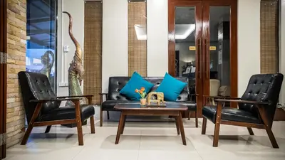 a living room with two chairs and a couch at Hemingway's Hotel in Patong Beach