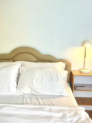 a bed with white sheets and a lamp on a table at Yada House Alina Cottage in Nai Yang Beach