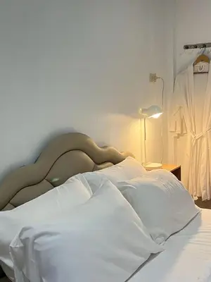 a white bed with a dress on top of it at Yada House Alina Cottage in Nai Yang Beach