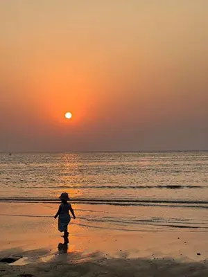 a person walking on the beach at sunset at Yada House Alina Cottage in Nai Yang Beach