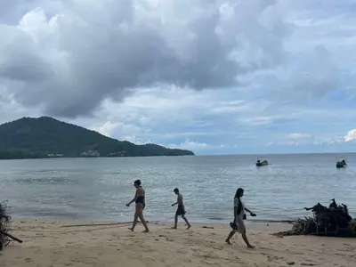 a group of people walking on the beach at Yada House Alina Cottage in Nai Yang Beach