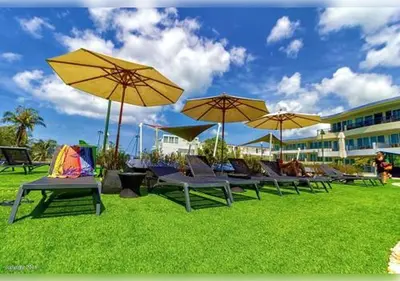a group of chairs and umbrellas on the grass at Karon Butterfly Residence in Kata Beach