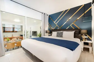 a bedroom with a large bed and a dining room at Cozystay Center of Patong near Bangla Road in Patong Beach