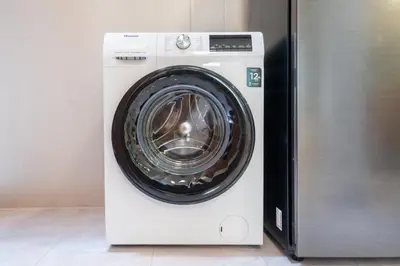 a white washing machine sitting next to a refrigerator at Cozystay Center of Patong near Bangla Road in Patong Beach