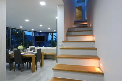a dining room with a table and chairs and stairs at 4BDR Sugar Villa 2 in Kamala Beach