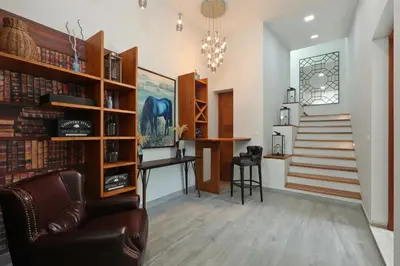 a living room with a staircase and a chair and a desk at 4BDR Sugar Villa 2 in Kamala Beach