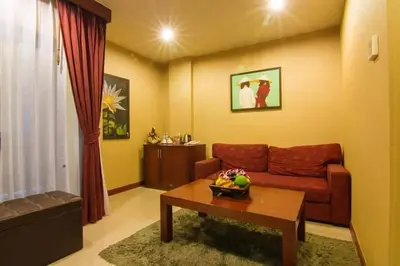 a living room with a couch and a table at Patong Hemingways Hotel in Patong Beach