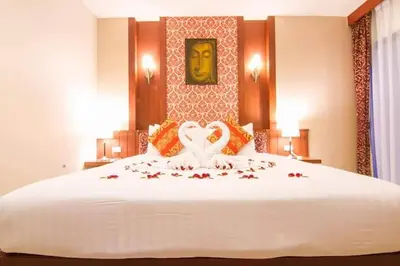 a bedroom with a large white bed with two hearts on it at Patong Hemingways Hotel in Patong Beach