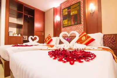two beds in a hotel room with hearts and roses at Patong Hemingways Hotel in Patong Beach