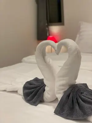 two towels shaped like swans sitting on a bed at Sunny Balcony in Ban Khlong Haeng
