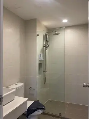 a bathroom with a shower with a glass door at Sunny Balcony in Ban Khlong Haeng
