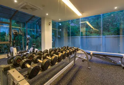 a gym with a row of dumbbells in a room at Sunny Balcony in Ban Khlong Haeng