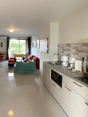 a living room with a couch and a living room with at Sunny Balcony in Ban Khlong Haeng
