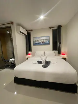 a bedroom with a white bed with a heart on it at Sunny Balcony in Ban Khlong Haeng