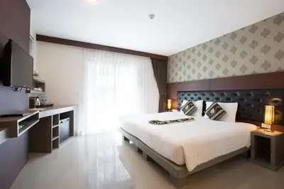 a bedroom with a large bed and a large window at Hemingways Silk Hotel in Patong Beach