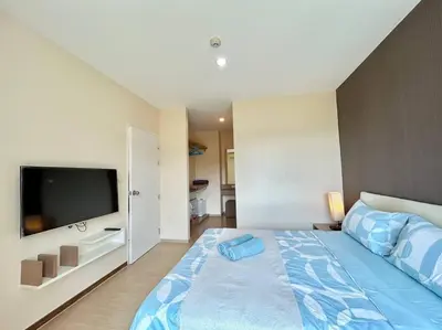 a bedroom with a large bed and a flat screen tv at 1 Large Bedroom in Prime Bangtao in Bang Tao Beach