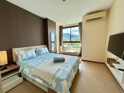 a bedroom with a large bed and a television at 1 Large Bedroom in Prime Bangtao in Bang Tao Beach