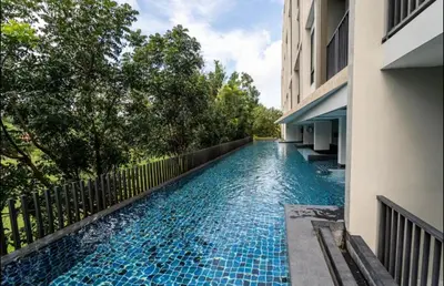 a swimming pool next to a building at 1 Large Bedroom in Prime Bangtao in Bang Tao Beach