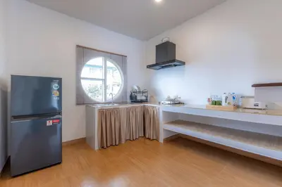 a kitchen with a stainless steel refrigerator and a window at Sunrise Serenity Phuket Resort in Karon Beach