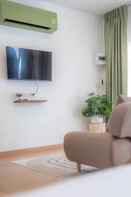 a living room with a couch and a flat screen tv at Sunrise Serenity Phuket Resort in Karon Beach