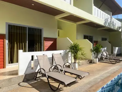 a row of chairs sitting on the side of a building at Sunrise Serenity Phuket Resort in Karon Beach