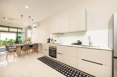 a kitchen with white cabinets and a table with chairs at VILLA Hinako Private Pool Nai Harn Beach in Rawai Beach